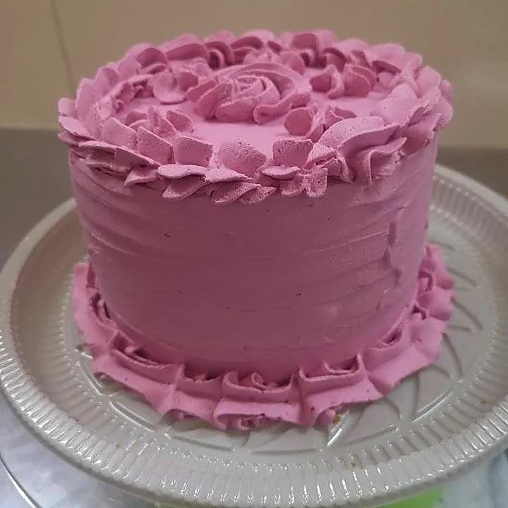 Torta rosa con decoración de rosas y bordes ondulados