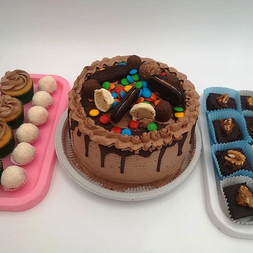 Deliciosa mesa dulce con torta de chocolate, cupcakes, brownies y bombones
