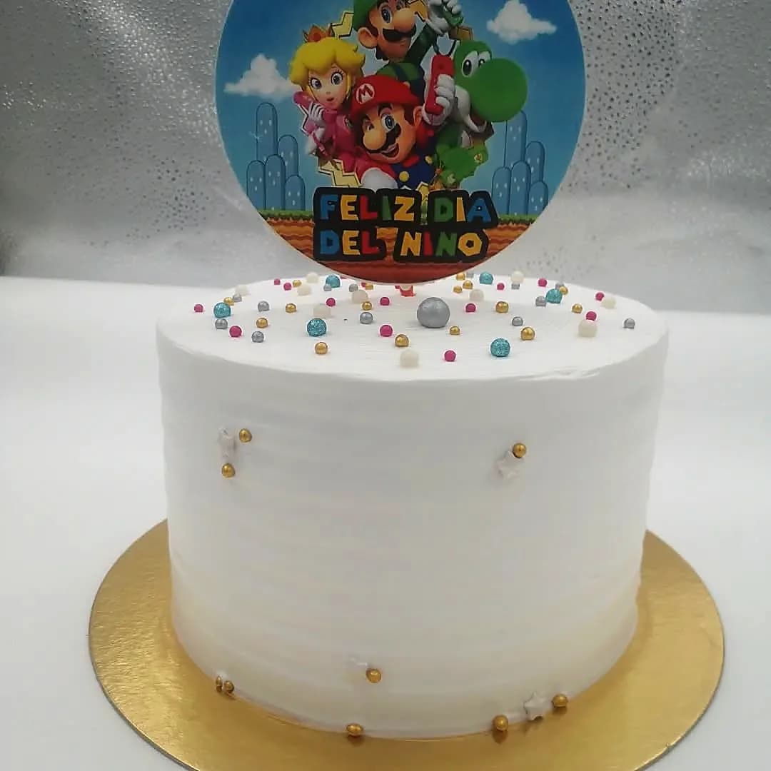 Torta blanca con decoración de Super Mario Bros y sprinkles de colores