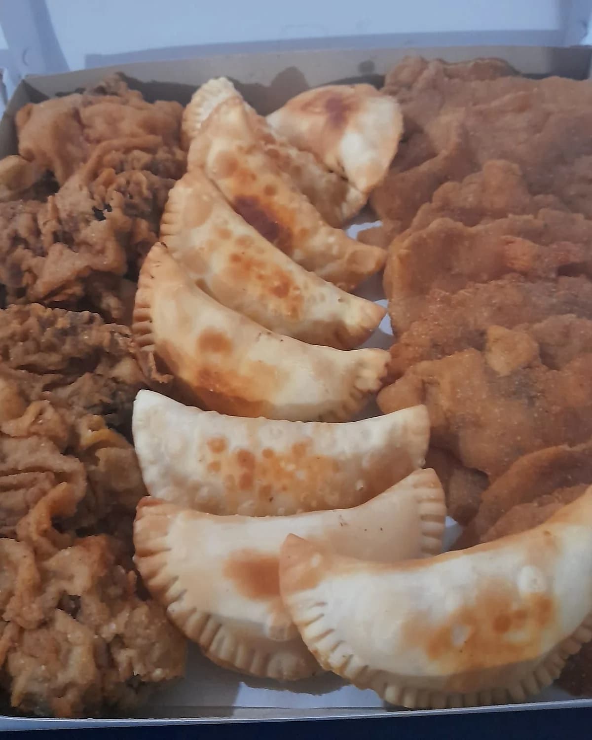 Bandeja de carton con surtido de bocaditos salados artesanales - empanaditas y croquetas doradas - para evento de 2M Reposteria en San Lorenzo