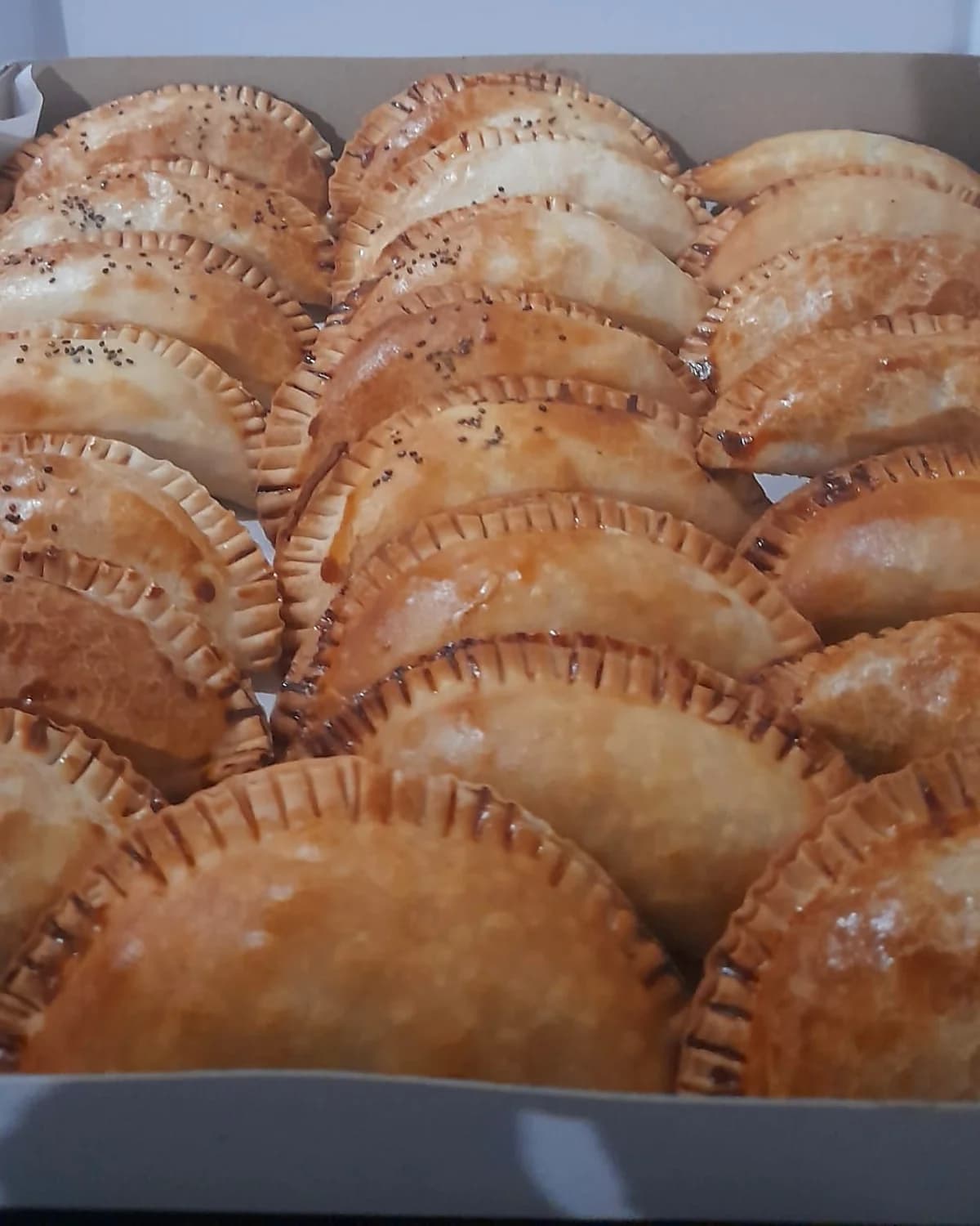 Bandeja completa de empanadas artesanales doradas y crocantes recien horneadas, hechas a mano por 2M Reposteria en San Lorenzo para eventos en Asuncion y Gran Asuncion