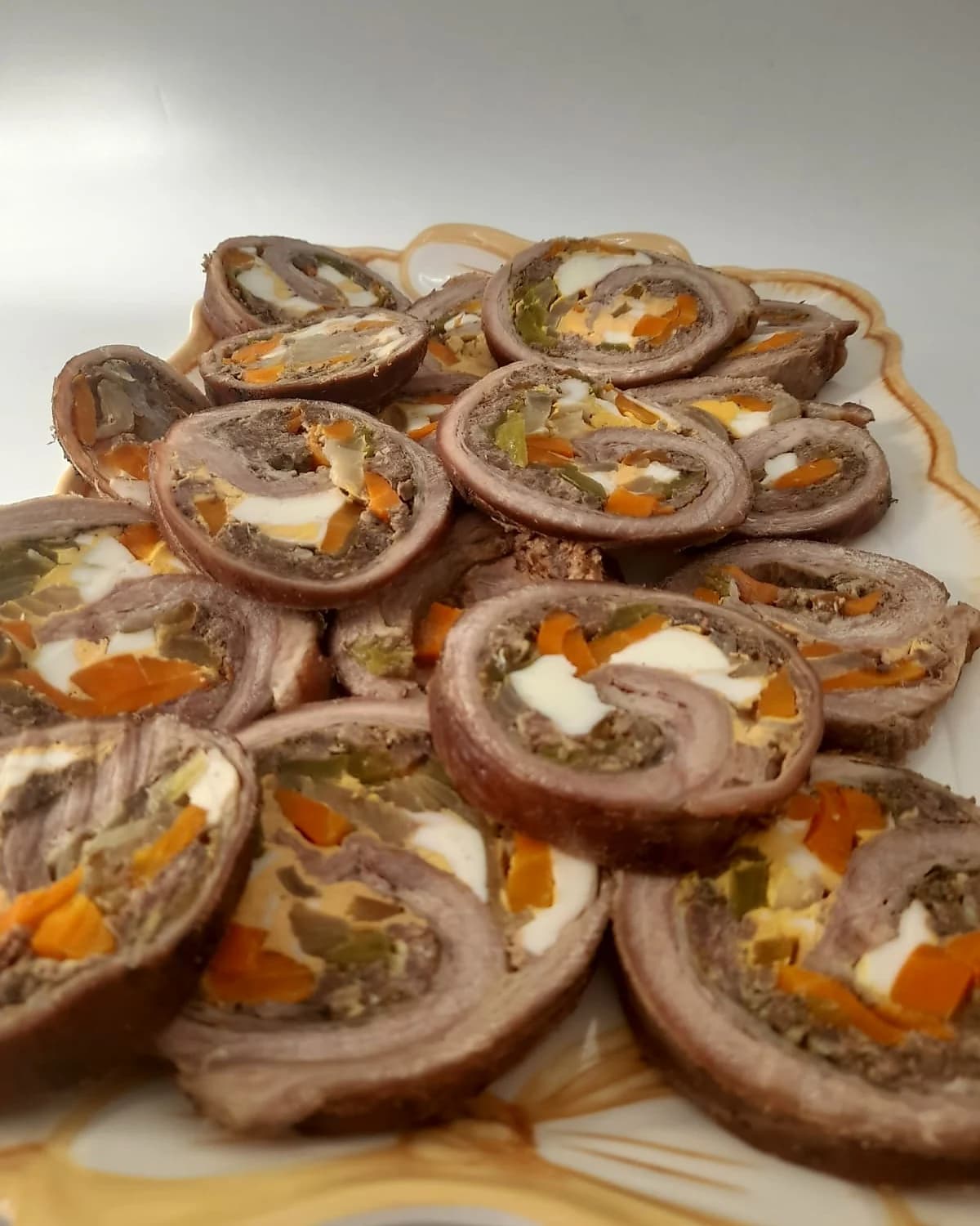 Plato decorado con rodajas de matambre arrollado paraguayo relleno con zanahoria, huevo y morron, presentacion de mesa de evento por 2M Reposteria en San Lorenzo