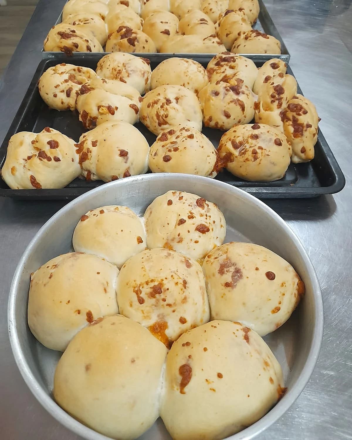 Bandejas de pan artesanal con trozos de chorizo y queso paraguayo, recién amasados en el estudio de 2M Repostería en San Lorenzo